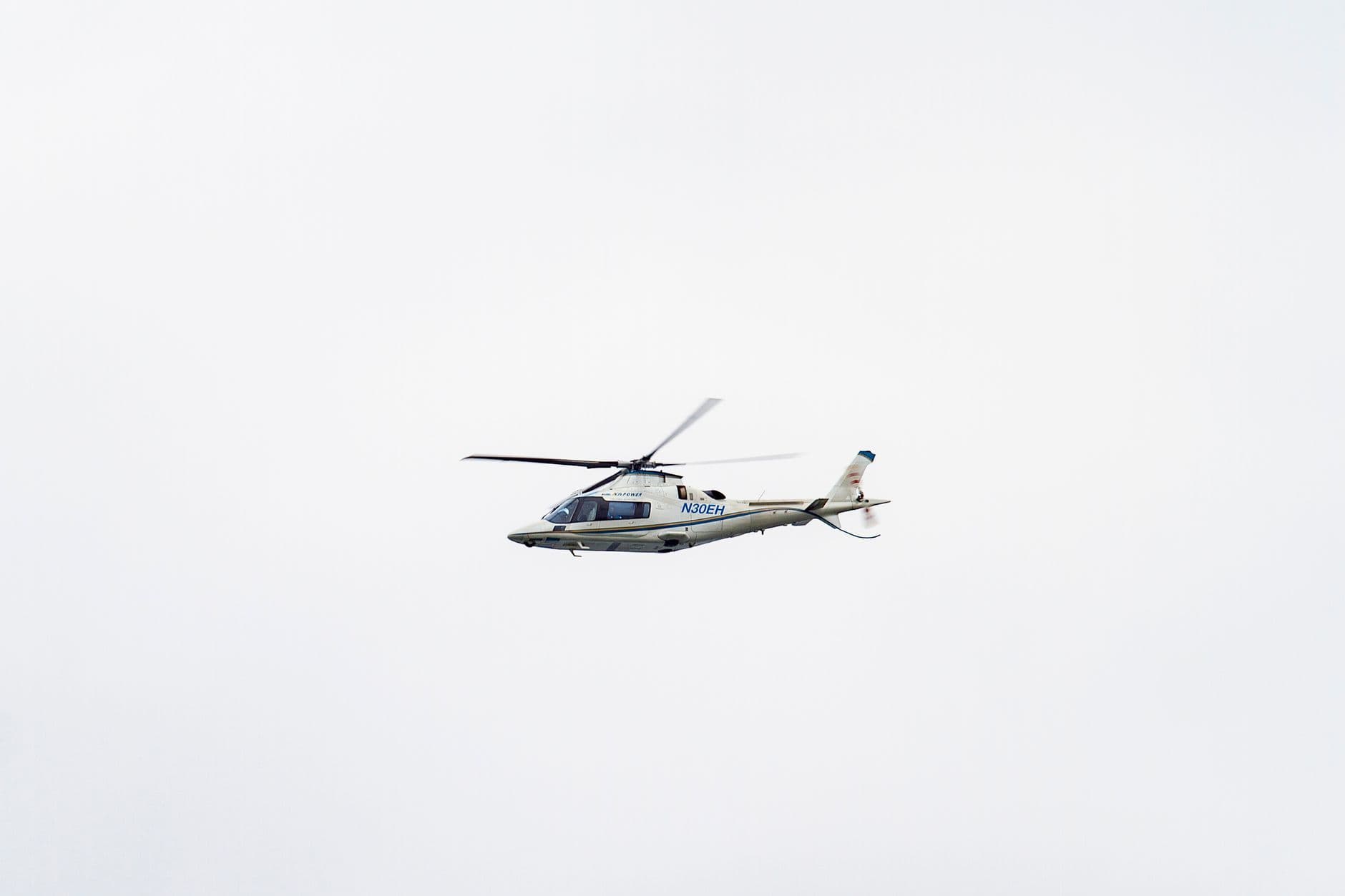 Helicopter flying against a pale sky