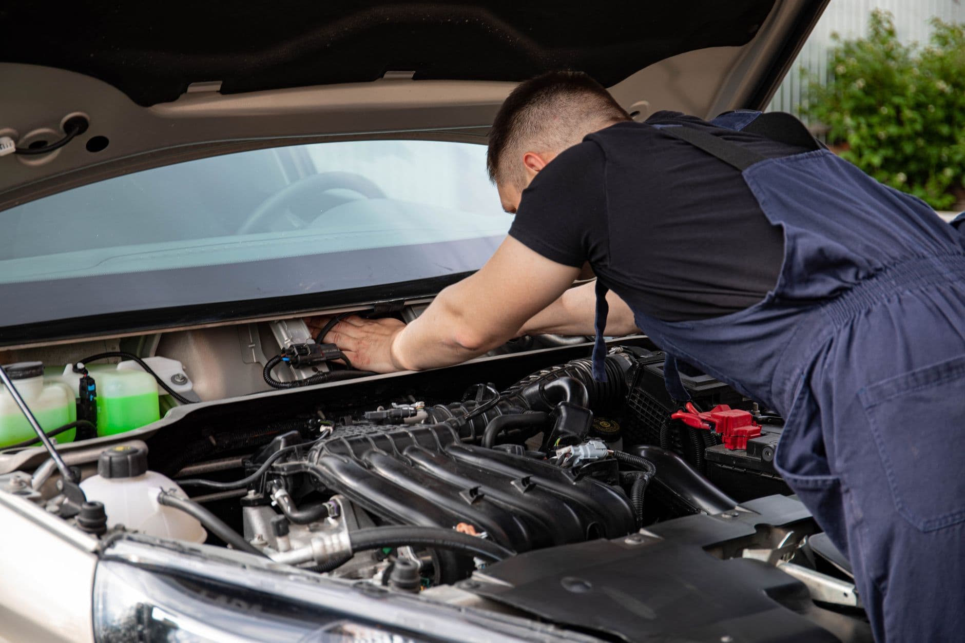 Mechanic leaning over an open car engine bay